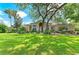 Charming home features a spacious lawn, mature trees, and tasteful landscaping at 1410 Livingston Rd, Lutz, FL 33559