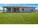 Spacious backyard showcasing the home's facade and offering ample green space for outdoor activities at 16077 Edina Ave, Port Charlotte, FL 33954