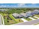 Aerial view of the property showing the landscaped lawn, trees, and neighborhood pond at 16139 69Th E Ln, Parrish, FL 34219