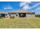 View of the backyard featuring a well-maintained lawn and a covered patio, perfect for outdoor relaxation at 16139 69Th E Ln, Parrish, FL 34219