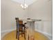Dining area featuring a unique wood table with two high stools in a well-lit space at 16139 69Th E Ln, Parrish, FL 34219