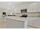 Bright kitchen featuring white cabinets, granite countertops, stainless steel appliances, and a center island at 16139 69Th E Ln, Parrish, FL 34219