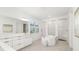 Elegant bathroom featuring a soaking tub, dual vanities, and a separate glass-enclosed shower at 16626 Paynes Mill Dr, Lakewood Ranch, FL 34211