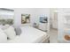 Bright, modern bedroom with white decor, a cozy bed, television, and an adjacent, immaculate bathroom at 16626 Paynes Mill Dr, Lakewood Ranch, FL 34211