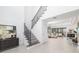 Elegant entryway with staircase and a view to the living area, featuring modern decor and light hardwood floors at 16626 Paynes Mill Dr, Lakewood Ranch, FL 34211