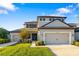 Charming two-story home featuring a manicured lawn and a three-car garage with individual doors in daytime at 16626 Paynes Mill Dr, Lakewood Ranch, FL 34211