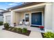 Inviting covered porch with double doors, seating, and manicured landscaping for a welcoming entrance at 16626 Paynes Mill Dr, Lakewood Ranch, FL 34211