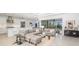 Open-concept living room featuring modern decor, a large sectional sofa, and seamless access to the outdoors at 16626 Paynes Mill Dr, Lakewood Ranch, FL 34211