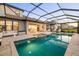 Outdoor dining area with grill, overlooking screened-in pool and interior living spaces at 16626 Paynes Mill Dr, Lakewood Ranch, FL 34211