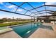 A screened in pool with lounge chairs and view of the backyard at 16626 Paynes Mill Dr, Lakewood Ranch, FL 34211