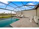 Inviting screened-in pool area with lounge chairs, umbrellas, and a view of the lake at 16626 Paynes Mill Dr, Lakewood Ranch, FL 34211