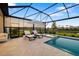 Relaxing screened-in pool and spa overlooking a pond with lounge chairs at 16626 Paynes Mill Dr, Lakewood Ranch, FL 34211