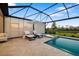 Screened in pool with lounge chairs, umbrella, and view of backyard at 16626 Paynes Mill Dr, Lakewood Ranch, FL 34211