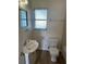 Cozy bathroom featuring a single vanity, toilet, window, and wood look floors at 1710 32Nd W St, Bradenton, FL 34205