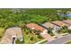 Expansive aerial shot with a beautiful lake view showing tile roofs, landscaping, and a brick driveway at 21287 Sandal Foot Dr, Venice, FL 34293