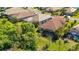 An aerial view showing the tile roof of the home with a screened lanai, and beautiful landscaping at 21287 Sandal Foot Dr, Venice, FL 34293