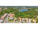 A beautiful aerial view of homes in a desirable community near a lake with mature landscaping at 21287 Sandal Foot Dr, Venice, FL 34293