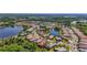 Expansive aerial view showcasing community homes and amenities with mature landscaping, and lake views at 21287 Sandal Foot Dr, Venice, FL 34293