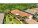 Aerial shot of the home showcases its well-kept yard, landscaping, tile roof, and brick driveway at 21287 Sandal Foot Dr, Venice, FL 34293
