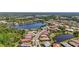 Scenic aerial view showcasing a planned community with mature landscaping, lake views, and neighborhood streets at 21287 Sandal Foot Dr, Venice, FL 34293