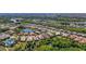 A vibrant aerial view of a Primary planned community, showcasing mature landscaping and lake views at 21287 Sandal Foot Dr, Venice, FL 34293