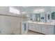 Bathroom featuring a white shower, a large mirror, and white cabinets at 21287 Sandal Foot Dr, Venice, FL 34293