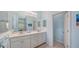 Bathroom with double vanity, a large mirror, and white cabinets at 21287 Sandal Foot Dr, Venice, FL 34293