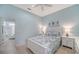 Comfortable bedroom featuring a bed with blue patterned linens, matching nightstands and an ensuite bath at 21287 Sandal Foot Dr, Venice, FL 34293