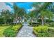 Inviting community entrance with lush landscaping, a paved walkway, and a clear view of the community pool at 21287 Sandal Foot Dr, Venice, FL 34293