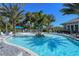 Unique community pool with a central island, palm trees, and ample lounge seating for residents to unwind at 21287 Sandal Foot Dr, Venice, FL 34293