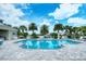 Stunning community pool area featuring a clear blue pool, lounge chairs, and meticulously maintained landscaping at 21287 Sandal Foot Dr, Venice, FL 34293