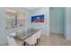 Elegant dining room boasts a glass table, seating for six, and natural light from a large window at 21287 Sandal Foot Dr, Venice, FL 34293