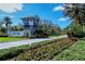 Grand Palm entrance showcasing lush landscaping, vibrant flowers, and a welcoming stone tower at 21287 Sandal Foot Dr, Venice, FL 34293