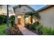 Charming front entrance with a brick walkway, manicured landscaping, and a welcoming front door at 21287 Sandal Foot Dr, Venice, FL 34293
