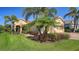 Inviting home exterior with lush lawn, vibrant landscaping, brick walkway, and attached two-car garage at 21287 Sandal Foot Dr, Venice, FL 34293