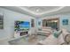 Cozy living room with a large screen TV, comfortable sofas, and plenty of natural light from the windows at 21287 Sandal Foot Dr, Venice, FL 34293