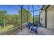 This screened patio includes brick pavers, a covered area, and serene views at 21287 Sandal Foot Dr, Venice, FL 34293