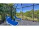 Relaxing screened patio features brick pavers, lounge chairs, and beautiful tropical landscaping at 21287 Sandal Foot Dr, Venice, FL 34293