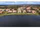Scenic aerial view showcasing homes along a lake with beautiful landscaping and mature trees at 2212 Weaver Bird Ln, Venice, FL 34292