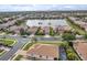 Community aerial view with houses nestled around a serene lake and lush green landscaping at 2212 Weaver Bird Ln, Venice, FL 34292