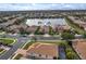 Aerial view of a community featuring well-maintained homes, landscaping, and a serene lake at 2212 Weaver Bird Ln, Venice, FL 34292