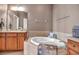Bright bathroom features a soaking tub with tile surround and double sink vanity at 2212 Weaver Bird Ln, Venice, FL 34292