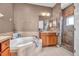 Bright bathroom features a soaking tub with tile surround and glass enclosed shower at 2212 Weaver Bird Ln, Venice, FL 34292