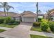Charming single-story home featuring a beautiful tile roof, paver driveway, and well-manicured landscaping at 2212 Weaver Bird Ln, Venice, FL 34292