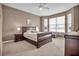 Inviting main bedroom featuring a window, ceiling fan, and a neutral color palette at 2212 Weaver Bird Ln, Venice, FL 34292