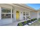 Inviting front porch with a bright yellow door, stylish seating, and thoughtful landscaping at 2220 Palm Ter, Sarasota, FL 34231