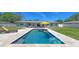 Inviting backyard pool with lounge chairs, umbrella, and outdoor seating, perfect for relaxation and entertaining at 2220 Palm Ter, Sarasota, FL 34231