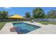 Inviting pool area with clear water, yellow umbrella, and poolside seating at 2220 Palm Ter, Sarasota, FL 34231