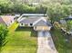 Aerial view of home showcasing well-manicured lawn, two-car garage, and lush landscaping at 2272 Palomar St, North Port, FL 34287