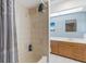 Bathroom with tiled shower and vanity with wooden cabinets and a sink at 2272 Palomar St, North Port, FL 34287